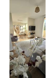 uma sala de estar com um sofá e flores num quarto em Superbe T3 cosy, parking gratuit + balcon em Riom