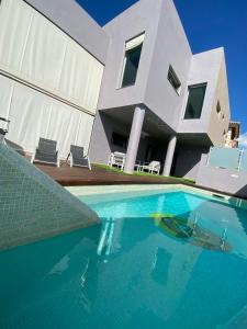 une maison avec une piscine en face d'une maison dans l'établissement Villa Los Almendros Fuengirola, à Fuengirola