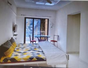 1 dormitorio con 1 cama y 1 mesa con sillas en 2 BHK flat with Kitchen and Free Wi Fi Kharadi,Pune en Pune