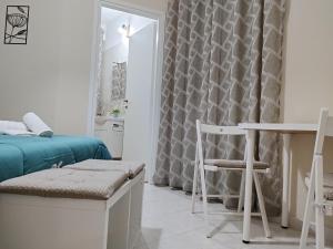 een slaapkamer met een bed en een tafel en stoelen bij L'Angolo di Sarah in Santo Stefano di Camastra