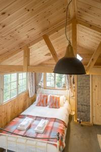 1 dormitorio con 1 cama grande en una habitación de madera en The Eco Cabin - Romantic & Cosy, en Brighton & Hove