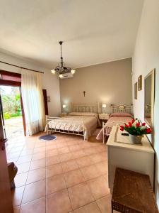 a bedroom with two beds and a table at Casolare Nelle Saline in Torre Nubia