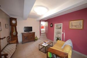 ein Wohnzimmer mit einem Sofa und einer Uhr in der Unterkunft La maison d'Anthonie, Roussillon in Roussillon