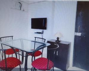 comedor con mesa de cristal y sillas en 2 BHK flat with Kitchen and Free Wi Fi Kharadi,Pune en Pune