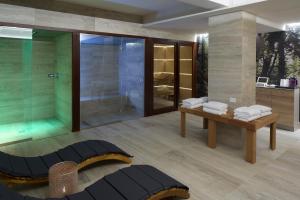 La salle de bains est pourvue d'une douche en verre et d'une table avec des serviettes. dans l'établissement Luci di Assisi B&B Wellness, à Assise