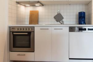 uma cozinha com armários brancos e um fogão em Ferienwohnung Saphir em Schilksee