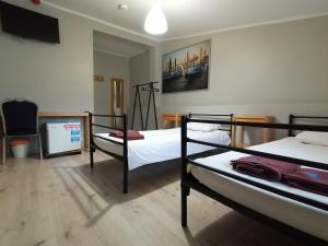 a room with three bunk beds and a flat screen tv at Hostel CENTRUM in Radom