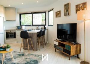 a living room with a television and a kitchen at MyStay - Casa das Oliveirinhas by Refúgio ao Luar in Celorico de Basto