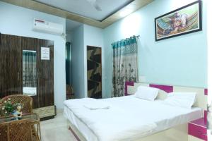 een slaapkamer met een groot wit bed in een kamer bij Radhe Radhe Guest House in Dehradun