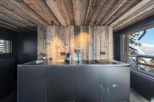 - une cuisine avec un évier et un mur en bois dans l'établissement Résidence Mazot De Bellecote - 3 Pièces pour 6 Personnes 804, à Courchevel