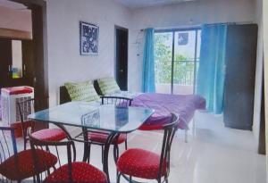 comedor con mesa de cristal y sillas en 2 BHK flat with Kitchen and Free Wi Fi Kharadi,Pune en Pune