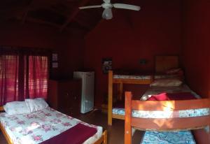 a bedroom with two bunk beds and a ceiling fan at La Ribera Hotel Dormis Camping in Villa Carlos Paz
