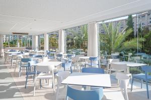 eine Cafeteria mit Tischen, Stühlen und Fenstern in der Unterkunft Apartamento con Vistas al Mar 1ºA in Benidorm