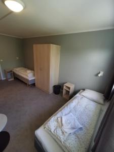 ein kleines Schlafzimmer mit 2 Betten und einem Schrank in der Unterkunft BiG Bed & Breakfast in Grimstad