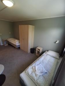 a small bedroom with two beds and a cabinet at BiG Bed & Breakfast in Grimstad