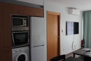 y cocina con microondas, lavadora y secadora. en K214 Apartamento Las Dunas Oliva Nova, en Oliva