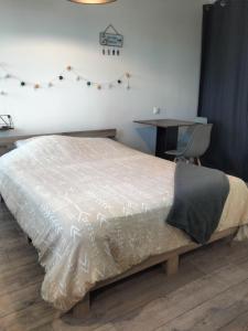 1 dormitorio con cama, escritorio y mesa en Logement indépendant avec extérieur privatif et clôturé, en Batz-sur-Mer