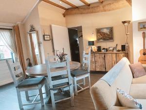 a kitchen and dining room with a table and chairs at Logeerboerderijtje De Rietkap Gieten in Gieten