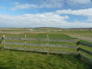 a wooden fence in the middle of a field at Madras cottage Orkney Islands in Harray