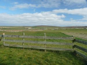 a wooden fence in the middle of a field at Madras cottage Orkney in Harray