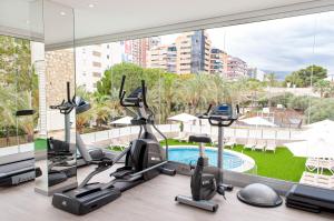 a gym with treadmills and exercise bikes in front of a window at Apartamento con Vistas al Mar Deluxe 4ºB in Benidorm