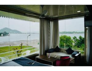 a room with a bed and a view of the water at Hotel Everest International,Udaipur in Udaipur