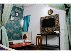 sala de estar con TV y mesa con silla en Hotel Everest International,Udaipur en Udaipur