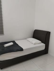 a bed with a black frame and white sheets at D'Mulya Homestay in Chemor