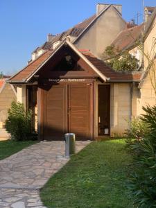 una casa con un grande garage in legno in un cortile di AUBERGE DU JEU D'ARC a Mello