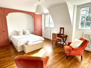 a bedroom with a bed and two chairs and a desk at La Meslaysienne - Comfortable house, swimming pool in Meslay-le-Vidame