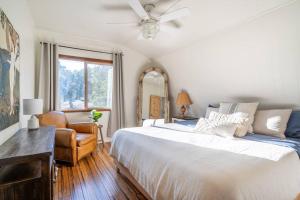 een slaapkamer met een groot wit bed en een stoel bij Mountain and Valley View with Hot Tub and BBQ in Frazier Park