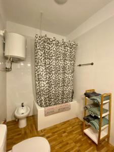 a bathroom with a toilet and a shower curtain at Toledo Sol Y Luna A desayuno Incluido in Manzaneque