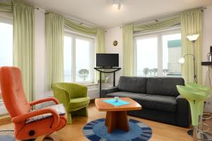 sala de estar con sofá, sillas y mesa en Villa Foerdestrand _ Spinnaker, en Laboe