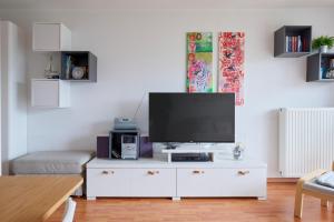 a living room with a flat screen tv on a white cabinet at Kapitaenshaus 10 in Laboe