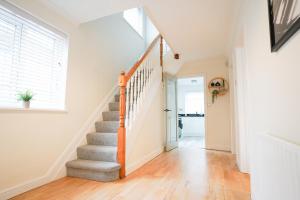 a staircase in a home with white walls and wood floors at Southampton 3 Bedroom Luxury House in Southampton