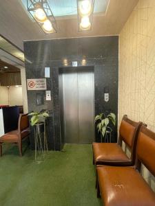 a waiting room with benches and a door with plants at Svaruchi Inn in New Delhi