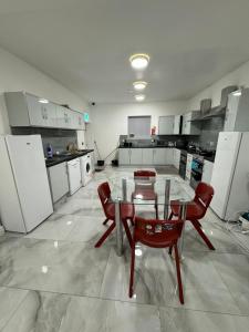 a large kitchen with a table and chairs in it at Vic Vic property in Oldham