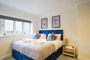 a bedroom with a blue bed with towels on it at Southampton 3 Bedroom Luxury House in Southampton