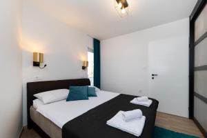1 dormitorio con 1 cama con 2 toallas en Dispetto apartment in old city, en Zadar