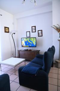 sala de estar con sofá azul y TV en Casa Philomena - Irpinia, en Lioni
