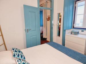 a bedroom with a bed with a blue door at Casa Azul by Ericeira Property in Ericeira