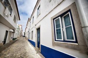 an alley with a blue door on a building at Casa Azul by Ericeira Property in Ericeira