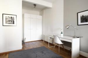 a white office with a desk and a chair at Kotimaailma Apartments Kamppi - spacious 1BR in Helsinki