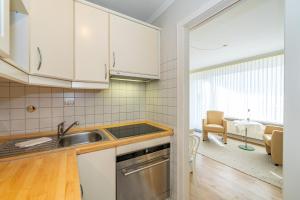 een keuken met witte kasten en een wastafel bij Haus Sola Bona Sola Bona App 34 in Westerland