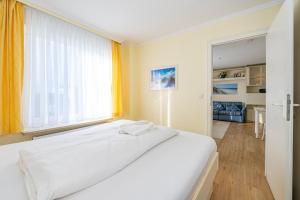 een wit bed in een kamer met een raam bij Haus Sola Bona Sola Bona App 34 in Westerland