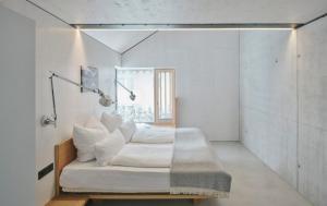 een witte kamer met een bed en een raam bij TIROLER TRIS Chalet & Penthouse in Maurach