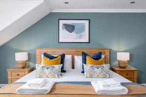 1 dormitorio con 1 cama con almohadas amarillas y azules en The Stirling Townhouse, en Stirling