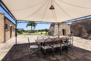 een tafel en stoelen onder een tent bij Masseria Relais Saraceno With Pool - Happy Rentals in Melendugno