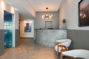 a lobby with a bar with chairs and a counter at Lym Flat Hotel in Uberlândia