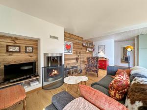 a living room with a couch and a fireplace at Magic view near slopes and termal bath - Swiss Alps in Ovronnaz